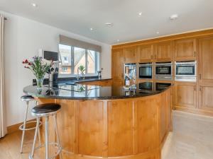 an island in a kitchen with wooden cabinets at Bide-a-wee in Wroxham