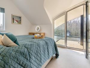 a bedroom with a bed and a large window at Bide-a-wee in Wroxham