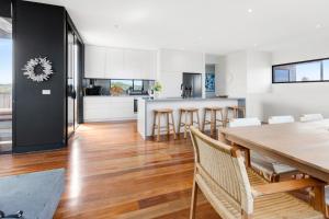 a kitchen and dining room with a table and chairs at Oceanic – Where Luxury Meets Tranquility in Rye