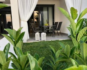 patio ze stołem, krzesłami i roślinami w obiekcie Kallithea love paradise pool & garden w mieście Kallithea
