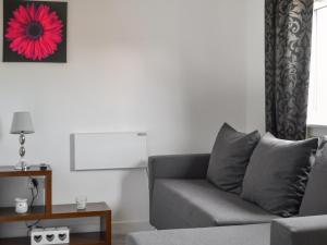 a living room with a couch and a red flower on the wall at Half Pint - Uk46614 in Tain