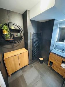 La salle de bains est pourvue d'un lavabo et d'un miroir. dans l'établissement Sublime Appartement Proche JO 2024, à Saint-Denis