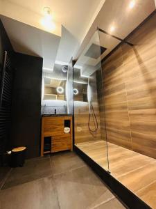 La salle de bains est pourvue d'une douche avec une porte en verre. dans l'établissement Sublime Appartement Proche JO 2024, à Saint-Denis