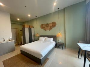 Un dormitorio con una gran cama blanca y una mesa en Zhong Xin Hotel en Phnom Penh