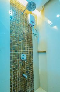 a bathroom with a shower with a tile wall at Hotel Palacio Puerto Princesa in Puerto Princesa City