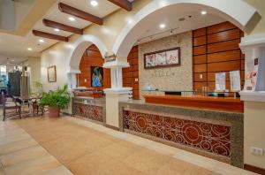un restaurant avec un bar dans un bâtiment dans l'établissement Hotel Palacio Puerto Princesa, à Puerto Princesa
