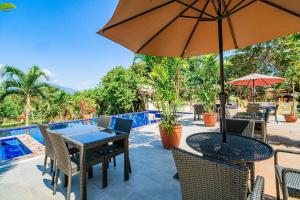 a patio with a table and chairs and an umbrella at Hotel Palacio Puerto Princesa in Puerto Princesa City