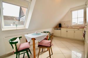 een kleine keuken met een tafel en stoelen bij Villa Wilhelma Apartment A2 1 OG in Timmendorfer Strand
