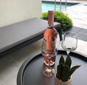 stół z butelką wina i dwoma kieliszkami w obiekcie Kallithea love paradise pool & garden w mieście Kallithea +15 zdjęć