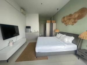a bedroom with a white bed and a flat screen tv at Zhong Xin Hotel in Phnom Penh