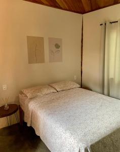 サン・ジョルジェにあるNamastê Suítes e Chalésのベッドルーム1室(白いベッドカバー付)