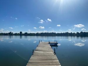 un muelle de madera en un gran lago con el cielo en CABAÑA CON MUELLE ORILLA LAGUNA, en Quillón