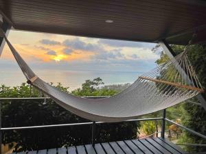 a hammock on a balcony with a view of the ocean at Villa Del Mar 2 Spectacular ocean view! in Dominical