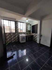 an empty room with a tile floor and a kitchen at Apartamento/Departamento Tarija in Tarija