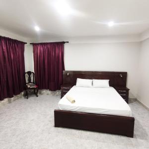 una camera con un grande letto e tende rosse di Apartamento/Departamento Tarija a Tarija