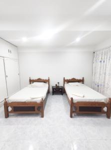 2 letti in una camera con pareti bianche di Apartamento/Departamento Tarija a Tarija