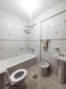 a white bathroom with a toilet and a sink at Apartamento/Departamento Tarija in Tarija