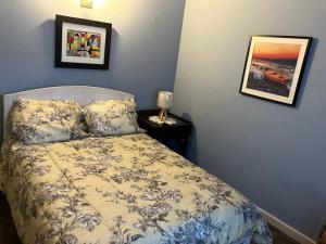 a bedroom with a bed and two pictures on the wall at The Residence - your home when not at home in Basse Terre Town