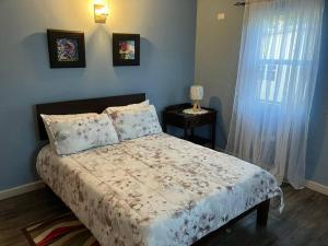 a bedroom with a bed and a table and a window at The Residence - your home when not at home in Basseterre