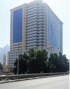 a large building with blue windows on the side of it at فندق ميزاب العدل مكة in Makkah