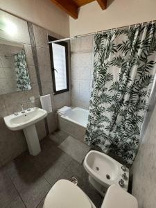 ein Badezimmer mit einem Waschbecken, einem WC und einer Badewanne in der Unterkunft El Nido Bombal in Godoy Cruz