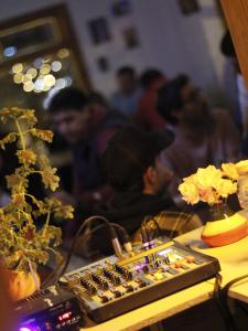 un grupo de personas de pie alrededor de una mesa con un tablero de ajedrez en Pintó Casa Hostel & Bar en Esquel
