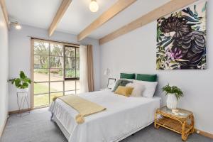 a bedroom with a large white bed and a window at Hot Springs Landing Pad in Rye
