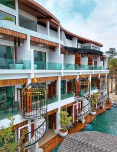 een appartementencomplex met vogelkooien op de balkons bij Hotel Villa AoKhanom in Khanom