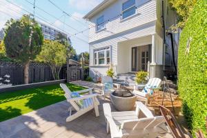 a patio with white chairs and a yard at Luxury Living, Walkers Paradise, Hidden Oasis in Oakland