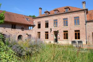 un vecchio edificio di mattoni con un mucchio di finestre di Le Domaine des Cigognes a Ennevelin