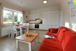 a living room with a red couch and a table at Haus am Hövt - Ferienwohnung 2 in Göhren