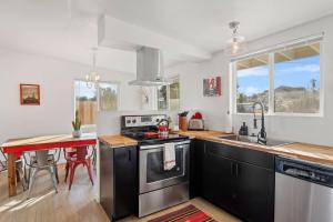 a kitchen with a stove and a sink and a table at Cozy Stylish Home in the Heart of JT Village in Joshua Tree