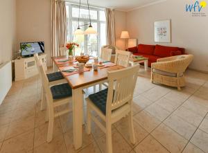 a kitchen and living room with a wooden table and chairs at Haus am Hövt - Ferienwohnung 3 in Göhren