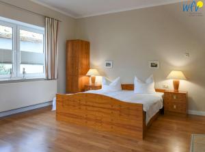 a bedroom with a large bed and a window at Haus am Hövt - Ferienwohnung 1 in Göhren