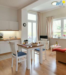 a kitchen and living room with a table and chairs at Haus am Hövt - Ferienwohnung 1 in Göhren