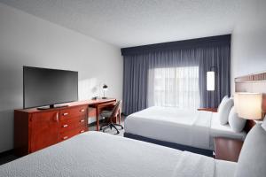 a hotel room with two beds and a desk with a television at Courtyard Kansas City Overland Park/Metcalf, South of College Boulevard in Overland Park +28 photos