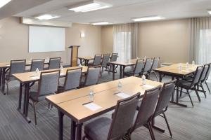 a conference room with tables and chairs and a whiteboard at Courtyard by Marriott Atlanta Airport South/Sullivan Road in Atlanta