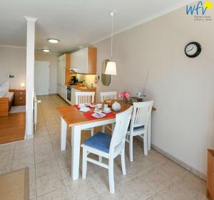 a kitchen and dining room with a table and chairs at Haus am Hövt - Ferienwohnung 10 in Göhren +25 photos