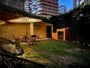危地馬拉的住宿－NoMAD House，庭院配有遮阳伞和桌椅。