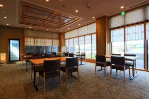 uma sala de conferências com mesas, cadeiras e janelas em 南郷温泉　二葉屋 em Otsu