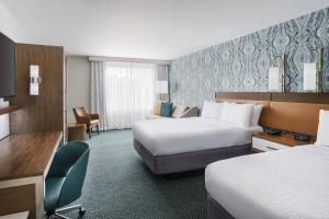 a hotel room with two beds and a desk at Courtyard by Marriott Orlando Downtown in Orlando