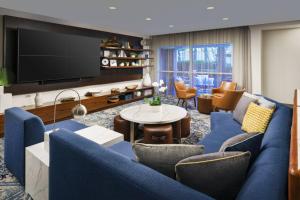 a living room with a blue couch and a tv at Courtyard by Marriott Orlando Downtown in Orlando