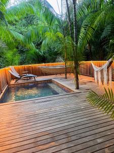 a swimming pool with a hammock on a wooden deck at Ti Kaz Açaï in Le Lamentin