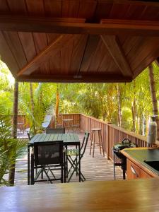 una terrazza in legno con tavolo e sedie. di Ti Kaz Açaï a Le Lamentin