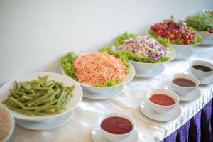 a table topped with bowls of different types of food at Lavender Nha Trang Hotel in Nha Trang