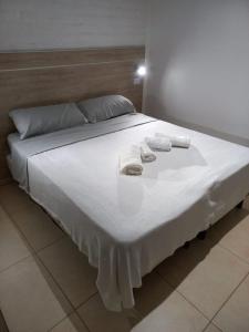 1 cama con 2 toallas y 2 almohadas en Grace Apartaments en San Juan