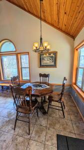a dining room with a table and chairs and a chandelier at Fishing Cabin on White River w/ public boat ramp! in Norfork