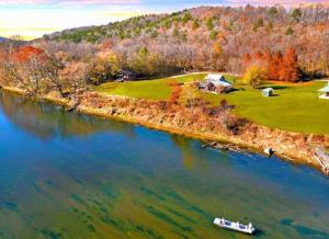 an island in the water with a boat in it at Fishing Cabin on White River w/ public boat ramp! in Norfork