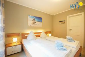 Un dormitorio con dos camas con toallas encima. en Ferienwohnung Weidenkieker, en Borkum
