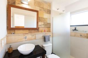 a bathroom with a sink and a toilet and a mirror at Kite Dream Cumbuco Apartments 60 & 120qm in Cumbuco